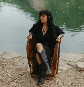 Woman sitting on a stone bench by a body of water with text overlay